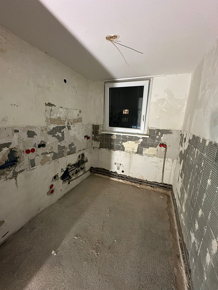 Gefliester Raum mit Steckdosen und Sanitärroharbeiten